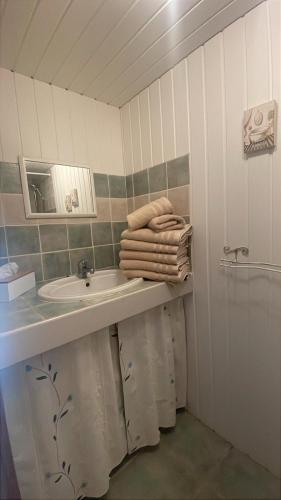 une salle de bain avec un lavabo, un miroir et des serviettes dans l'établissement Mas d'Ambayrac chambres d'hôte Le four a pain, à Promilhanes