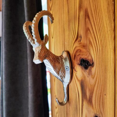 an animal head hanging on a wooden door at Villa Bischofsberg - Lärchen-Wellness Apartment in Windischgarsten