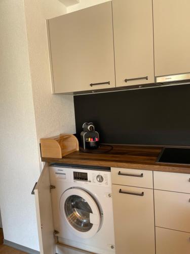 a kitchen with a washing machine in a kitchen at Saaserhof Apartments in Saas-Fee