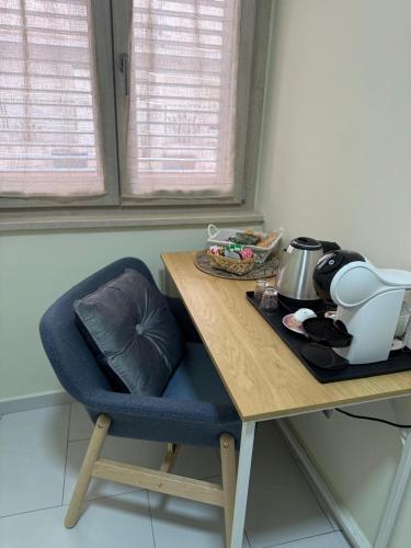 une table avec une chaise bleue et une table en bois avec une théière dans l'établissement Perla Marina B&B, à Nicotera Marina