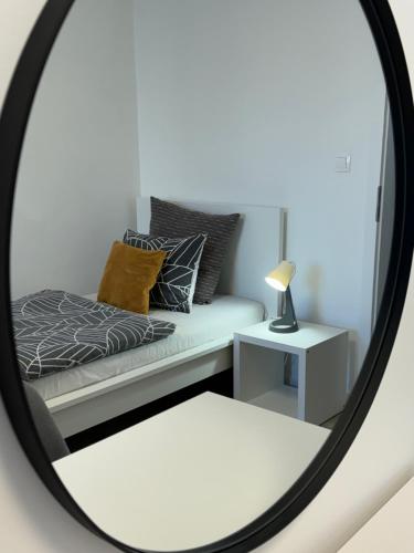 a mirror reflecting a couch with pillows and a lamp at Sonas in the city center in Karlovac