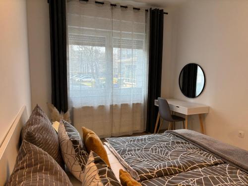 a bedroom with a bed and a window with a desk at Sonas in the city center in Karlovac