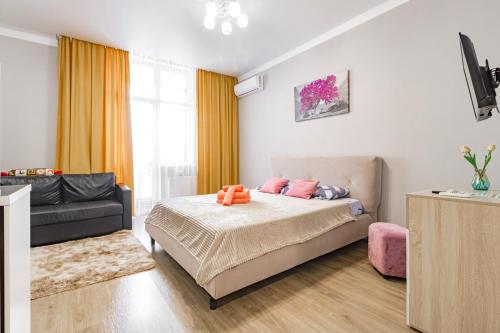 a bedroom with a bed and a couch at Цветущий сад in Astana