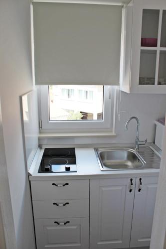 a small kitchen with a sink and a window at Adriona apartments with parking in Makarska
