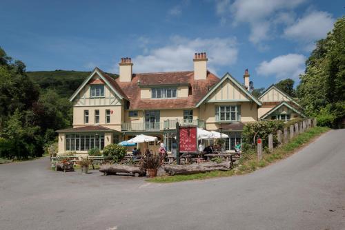 a large house with tables and chairs in front of it at The Hunters Inn in Martinhoe