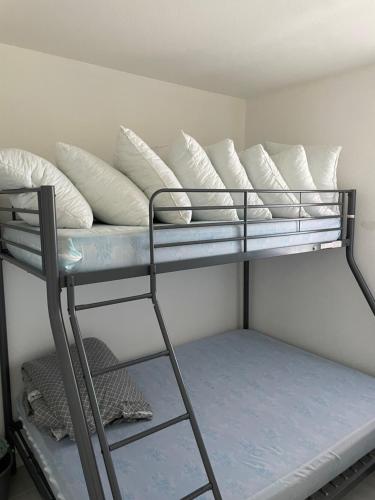 a bunk bed with white pillows on top of it at Appartement Marina in Le Barcarès