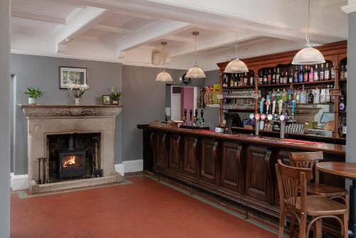 a bar with a fireplace in a room at The Hunters Inn in Martinhoe