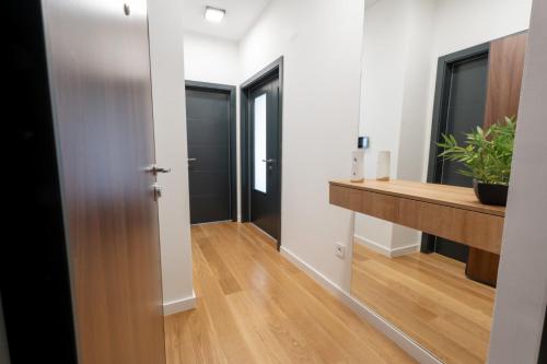 Apartman VISTA FIUME في تريبينيي: ممر بجدران بيضاء وطاولة خشبية وباب