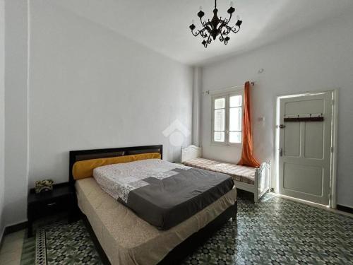 a bedroom with a bed and a window and a chandelier at Villa atypique Sousse Quartier chic in Sousse