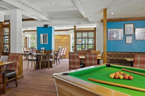 a pool table in a restaurant with tables and chairs at Sparrow Hotel in Ansty