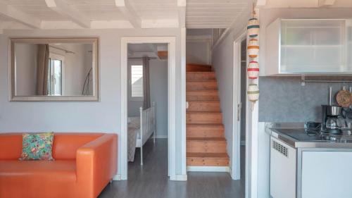 a living room with an orange couch and a staircase at Camping Grande Italia in Chioggia