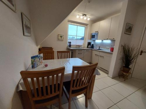 a kitchen with a table and chairs and a kitchen with a window at Birkenquartier in Zingst