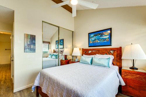 a bedroom with a large bed and a mirror at Walk to Nawiliwili Harbor Condo with Saltwater Pool in Lihue