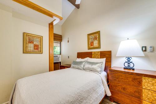 a bedroom with a bed and a lamp on a dresser at Walk to Nawiliwili Harbor Condo with Saltwater Pool in Lihue