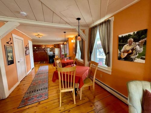 a dining room with a table and a guitar on the wall at Jamaicahaus in Jamaica