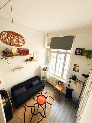 - un salon avec un canapé noir et une fenêtre dans l'établissement Central Paris Stay with Exceptional Comfort, à Paris