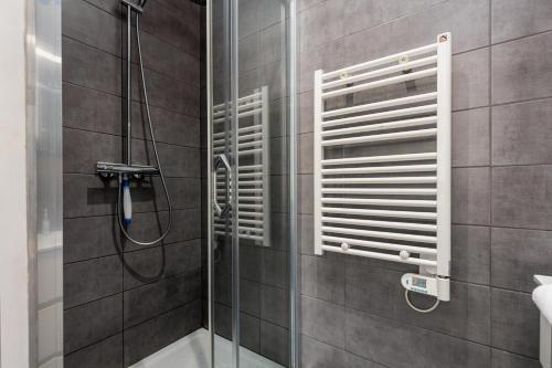 une douche avec une porte vitrée dans une salle de bain dans l'établissement Moneghetti, à Beausoleil
