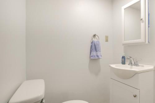 a white bathroom with a toilet and a sink at 1 Mi to Burr Oak Lake Home with Deck and Patio! in Corning