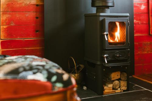 a wood stove with a fire in it at Sycamore and Stars Off Grid Retreat in Grasby