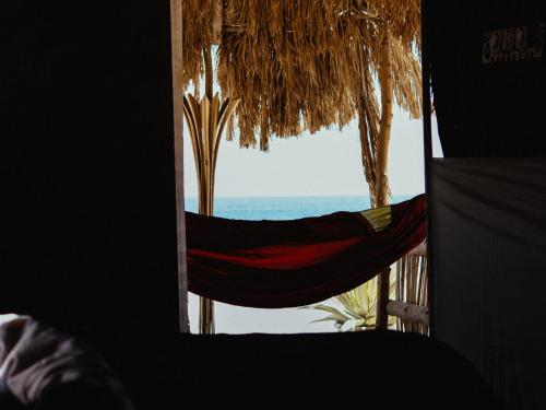 a view of the ocean from a room with a hammock at Natural Lodge in Dahab