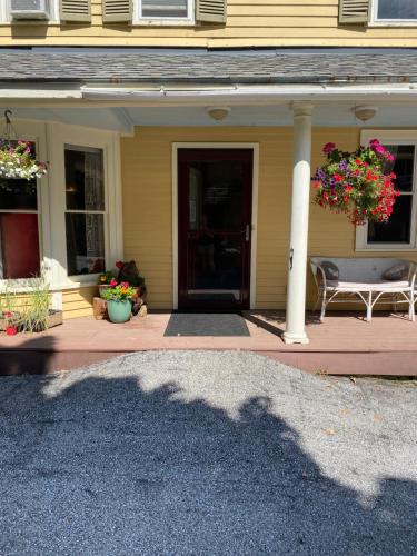 a front porch of a house with a bench and flowers at Jamaicahaus in Jamaica