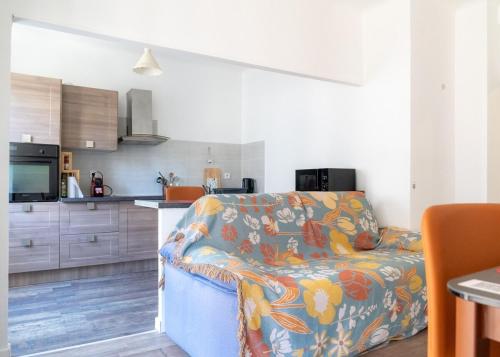 a living room with a couch and a kitchen at 2 pièces - Clim - tram à 5' centre à 15' in Nice