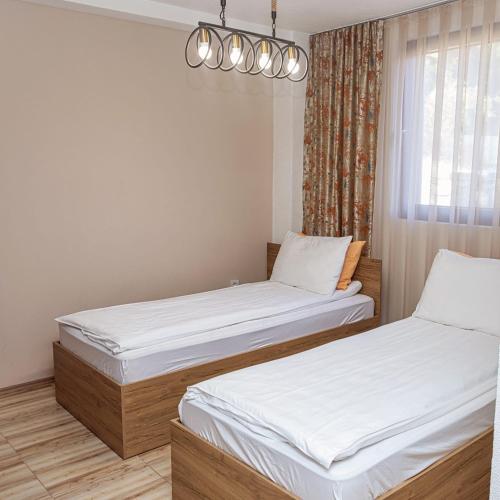 a bedroom with two beds and a window at Konak Hilltop Lodge & Villa in Kruševo