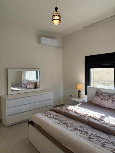 a bedroom with two beds and a mirror at Modern 2BR in Trendy Jabal AlWebdeh with View in Amman
