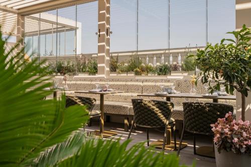 a restaurant with tables and chairs and plants at Vincci Mae in Barcelona