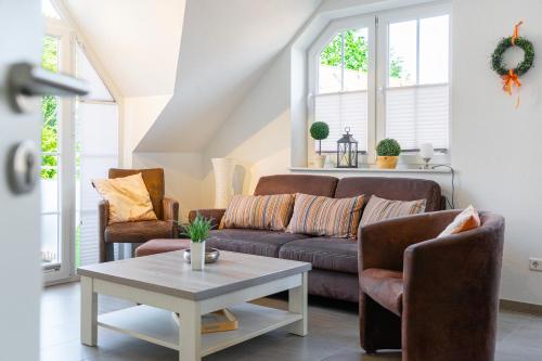 a living room with a couch and two chairs at Windrose in Greetsiel