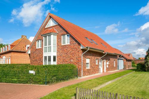 a brick house with an orange roof at Heubude in Greetsiel