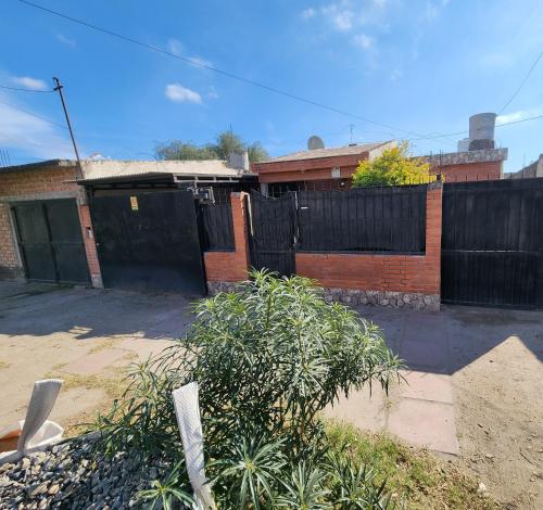 a house with a black gate and a brick fence at Hospedaje Choya in San Fernando del Valle de Catamarca