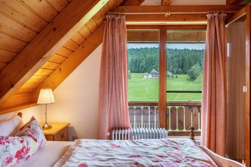 a bedroom with a bed and a large window at Ferienwohnung Weiherblick in Hornberg