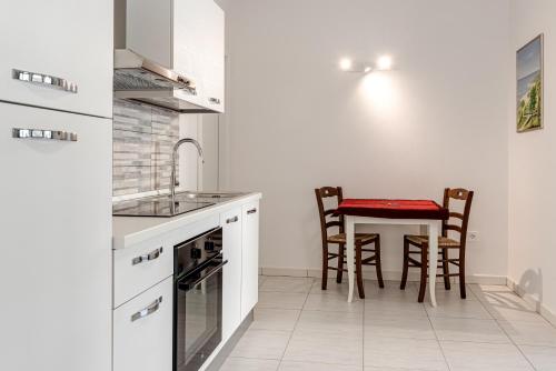 a white kitchen with a table and chairs at Fossato 37 Flat Pontassieve in Pontassieve