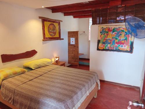 a bedroom with a bed and a painting on the wall at Hostel La Ballena Backpacker in Las Galeras