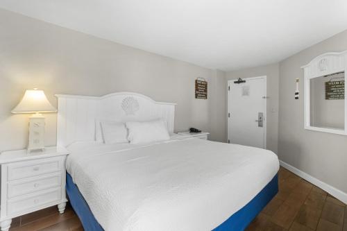 a white bedroom with a white bed and a white dresser at Monterey Bay Suites in Myrtle Beach