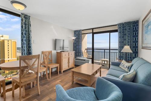 a living room with a blue couch and a table at Monterey Bay Suites in Myrtle Beach