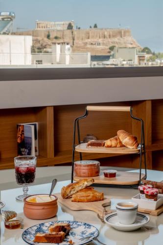 a table with plates of pastries and bread on a table at Apeiron Athena Residences in Athens