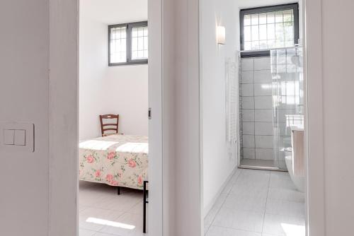 a white room with a bed and a bathroom at Fossato 35 Flat Pontassieve in Pontassieve