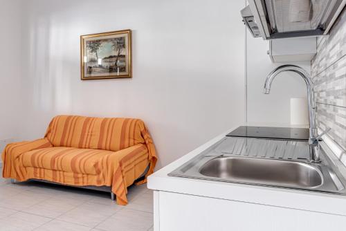 a kitchen with a sink and a chair next to a sink at Fossato 35 Flat Pontassieve in Pontassieve