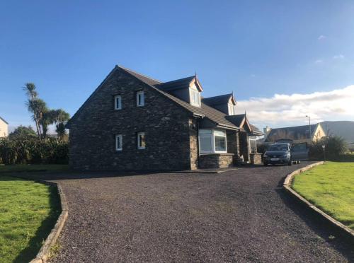 a stone house with a car parked in the driveway at The Stone House in Murreagh