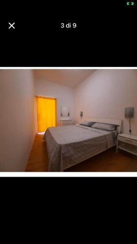 1 dormitorio con cama y ventana amarilla en casa dragonetti, en Marina di Ragusa