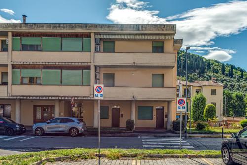 a building with cars parked in a parking lot at Fossato 35 Flat Pontassieve in Pontassieve