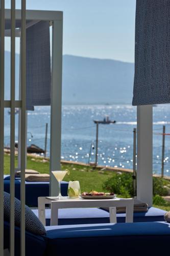 a room with a table and a view of the ocean at Atlantica Nissaki Beach - Adults Only in Gimari