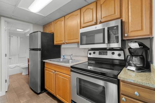a kitchen with stainless steel appliances and wooden cabinets at Monterey Bay Suites in Myrtle Beach