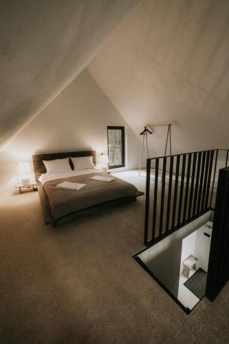 a attic bedroom with a bed and a mirror at Domek w Lesie in Rozogi