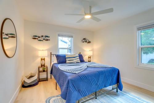 a bedroom with a blue bed and a ceiling fan at Private Hot Tub and Fenced Yard Sleek Gulfport Home in St Petersburg
