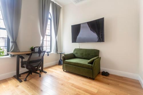 a living room with a green chair and a desk at Little manhattan near Time Square in New York