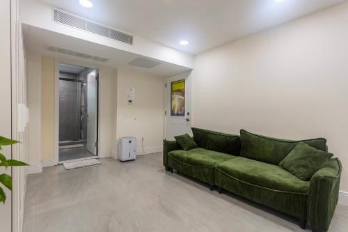 a living room with a green couch in a room at Little manhattan near Time Square in New York
