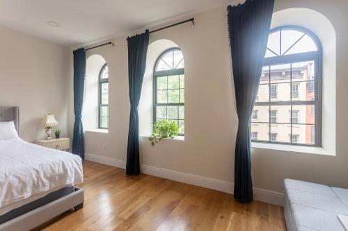 a bedroom with two arched windows and a bed at Little manhattan near Time Square in New York